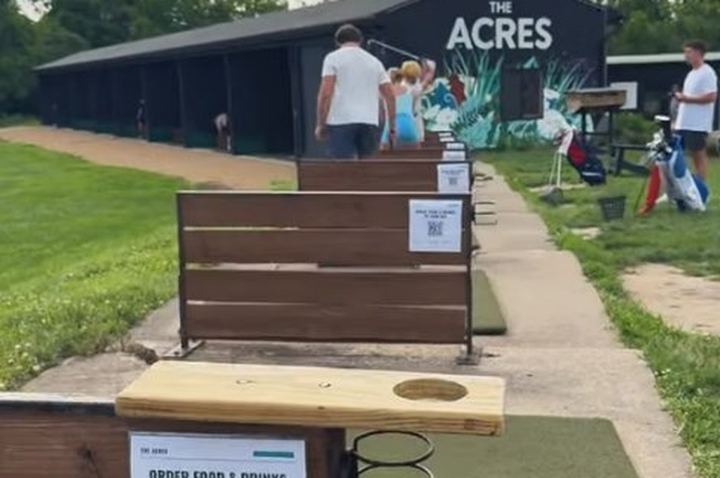 The Acres driving range bays with QR code signs to order food and drinks to your bay
